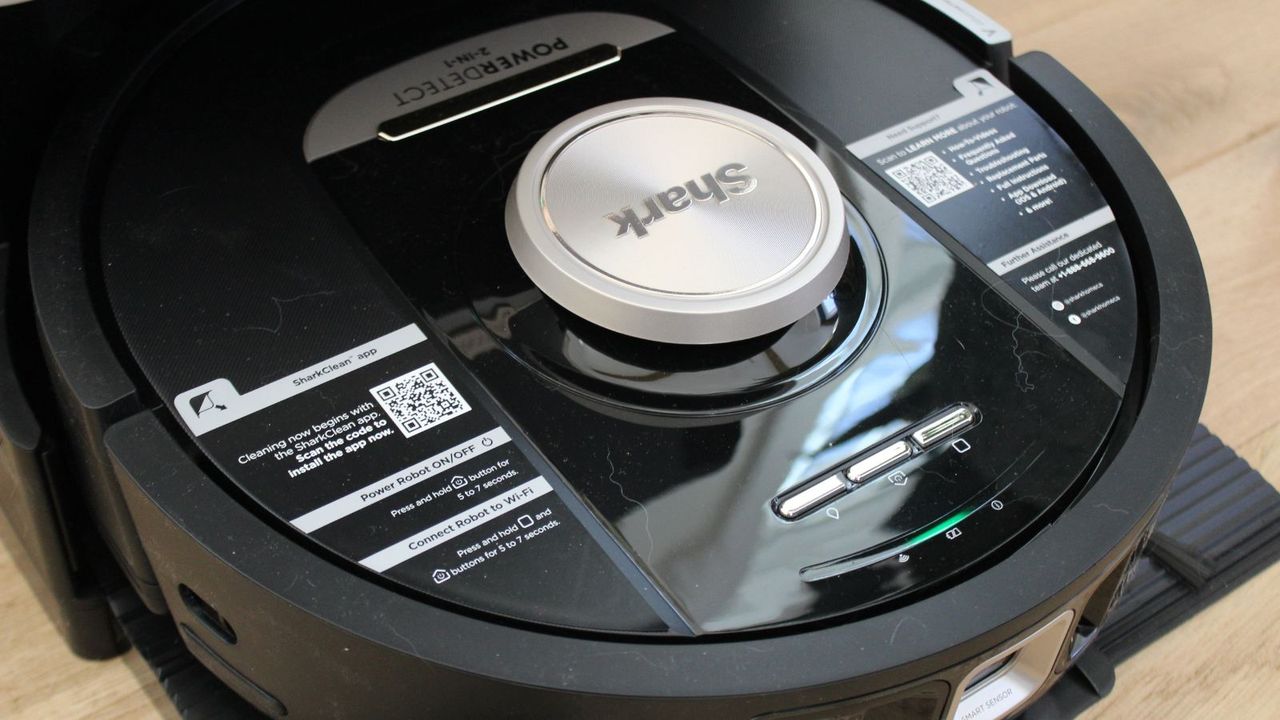 Close-up of the Shark PowerDetect 2-in-1 Robot Vacuum and Mop with NeverTouch Base Pro on wooden floor