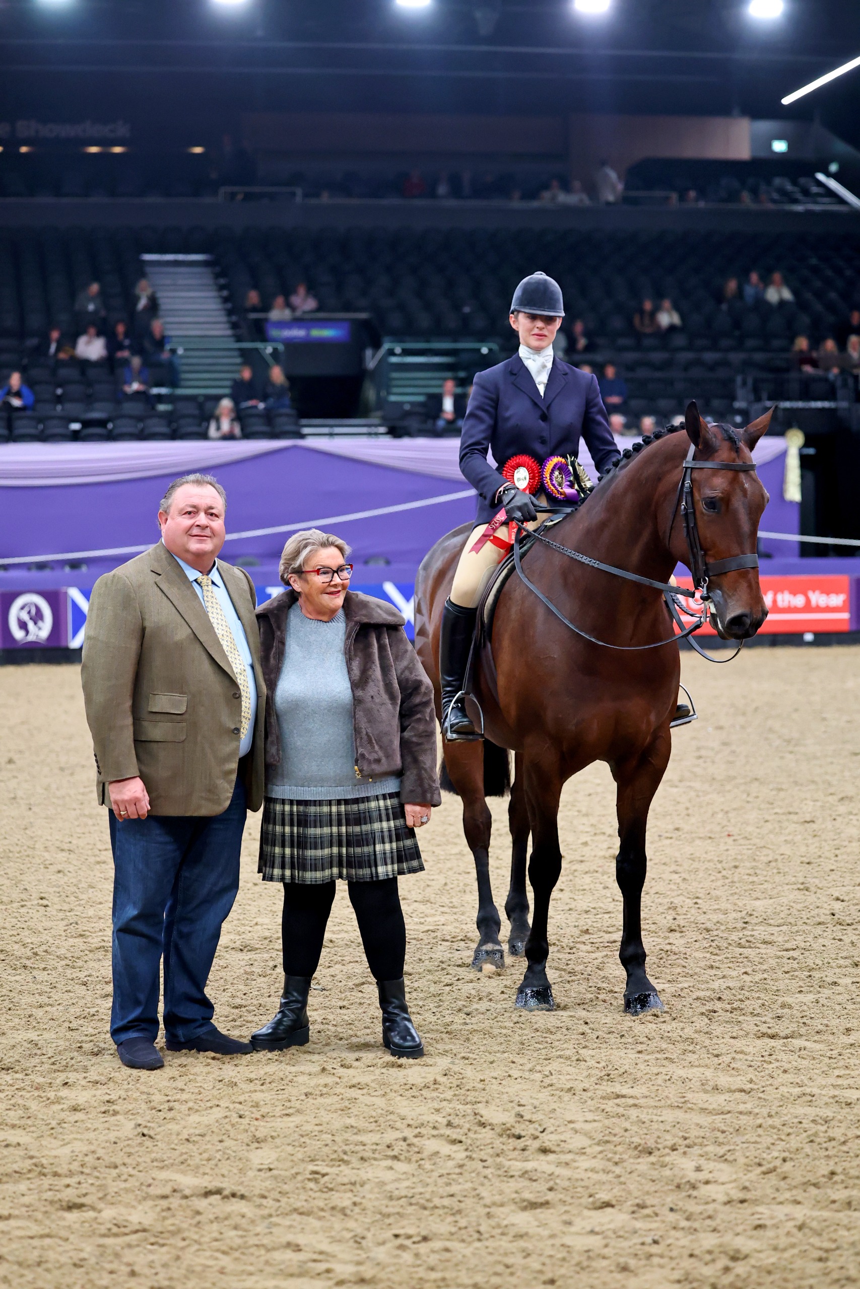 Tigbourne and Hannah Horton stand beside sponsors for a photo