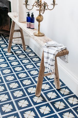 blue tile effect vinyl bathroom flooring, bench with tool, jug and candelabra