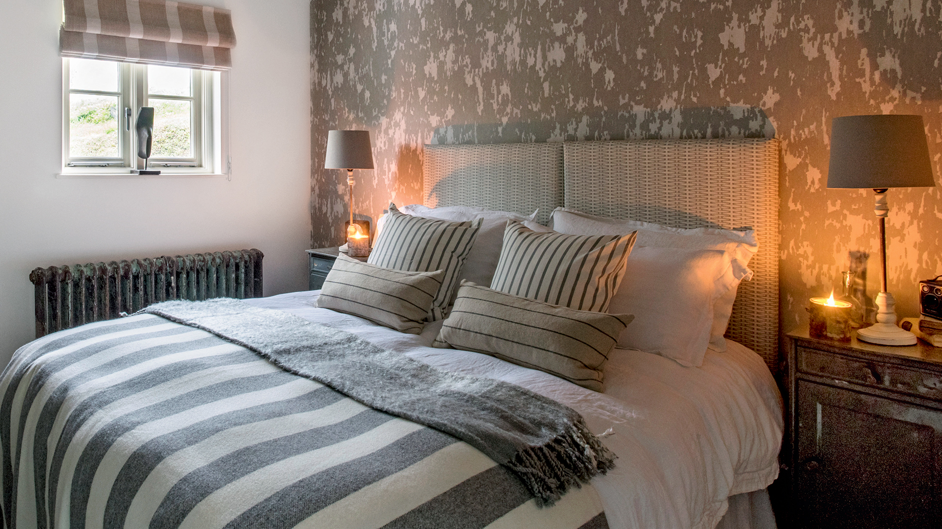 cosy autumn bedroom with bedside lamps on and candles