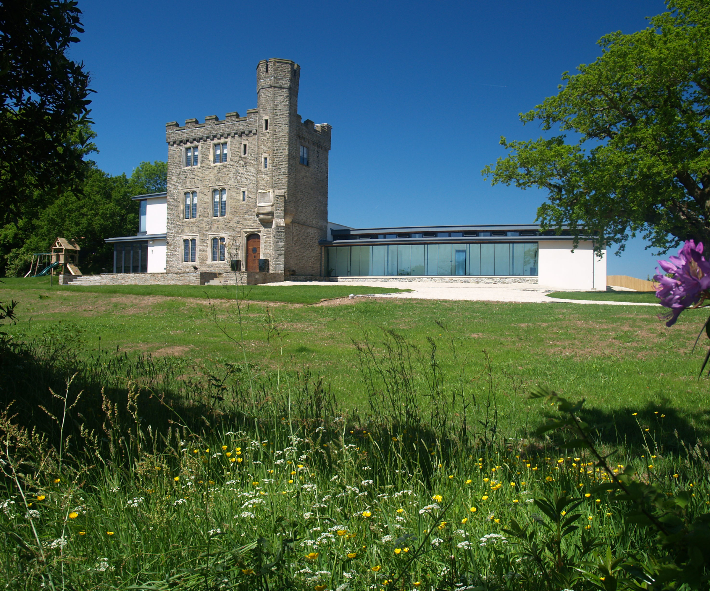 grade II listed folly with large wrap around extension on both sides, with double storey section on left hand side
