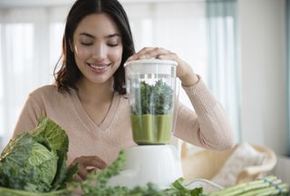 Woman blending a smoothie for a 7 day detox