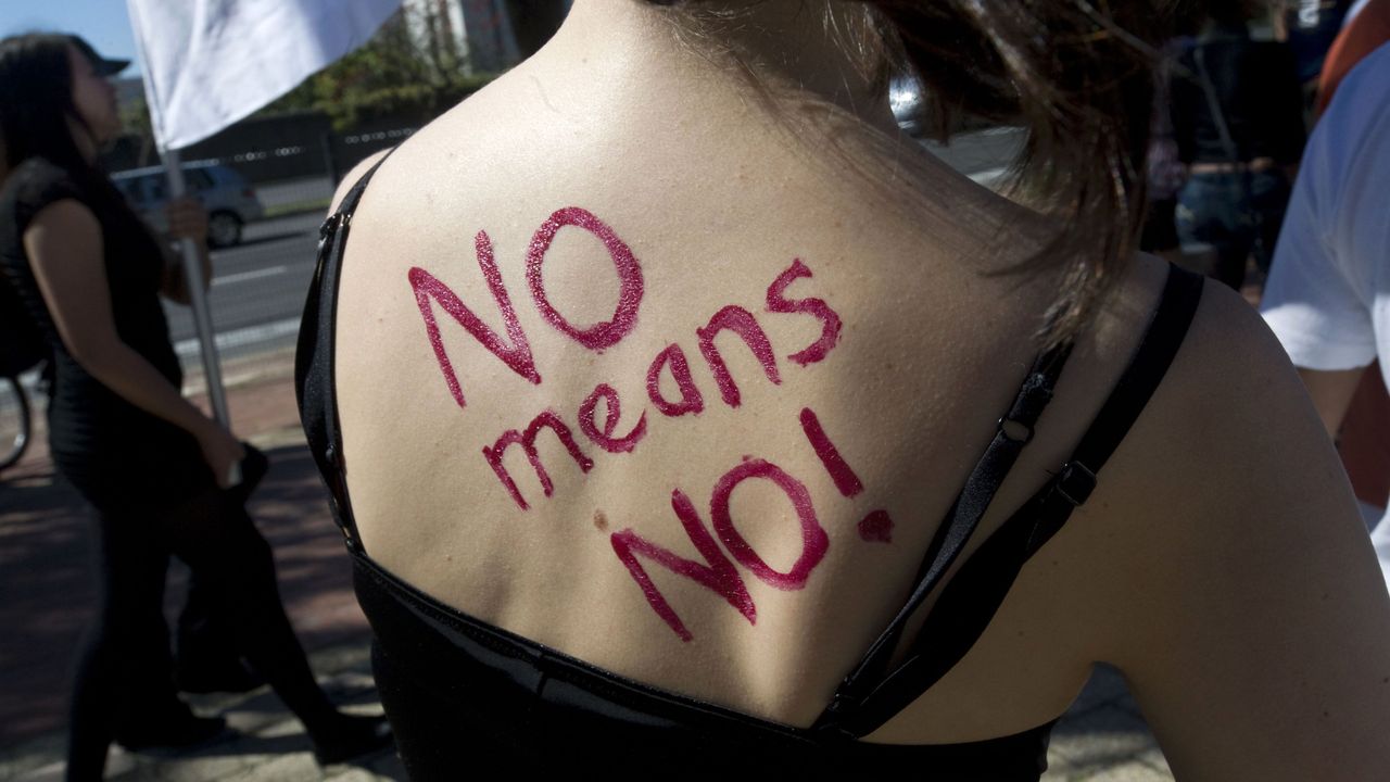 &quot;NO means NO!&quot; written in red lipstick on a woman&#039;s back