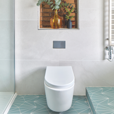 white toilet in bathroom with blue geometric tiles