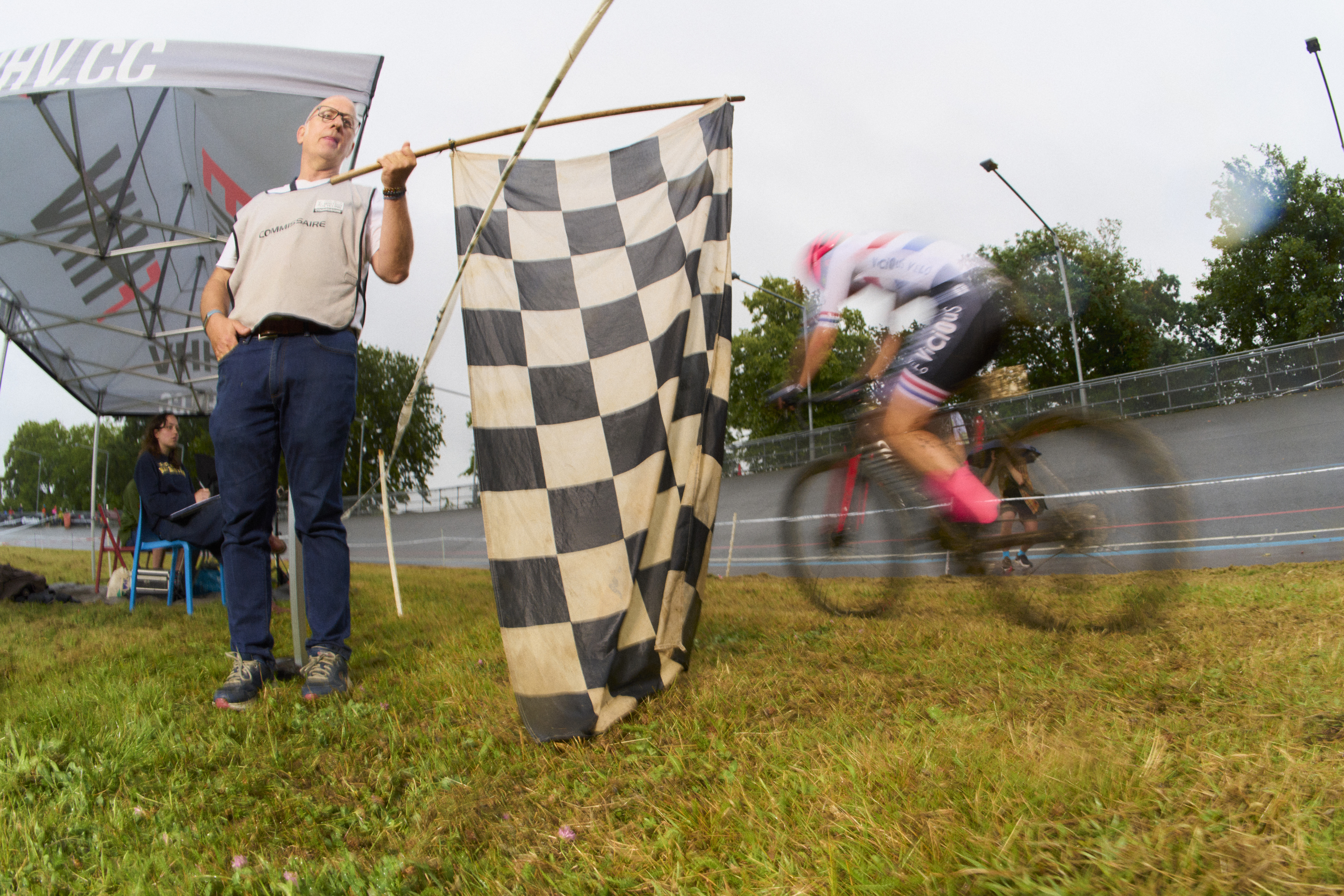 Finish line sign waves next to a blurry rider