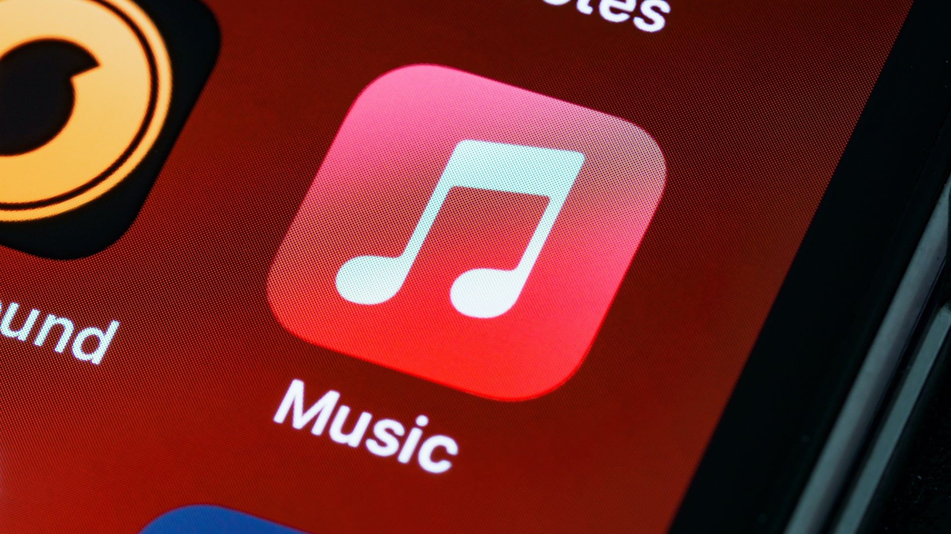 نماد برنامه Apple Music در پس زمینه قرمز در آیفون.