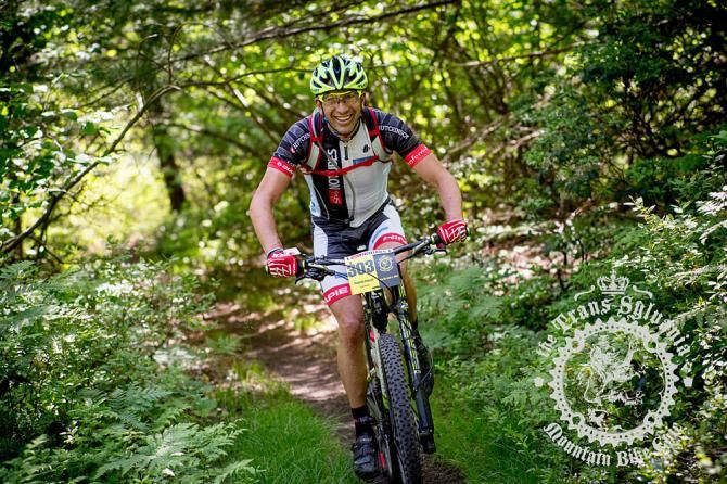 Stephan Kincaid riding through a tunnel of foliage.