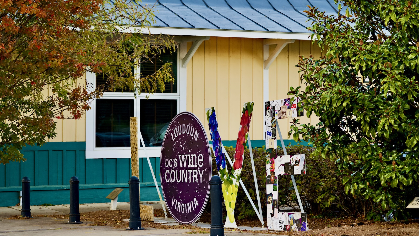 A sign saying 'D.C's Wine Country, Loudoun, Virginia&amp;quot; in front of a LOVE sculpture and a cream-and-green building