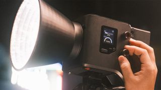 An individual adjusting the dial on the SmallRig light panel