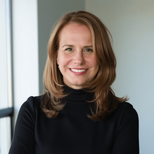 Image of a woman in a black turtleneck sitting in front of a light blue background.