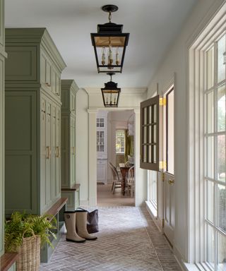 Hallway with pale green sage cupboards, stone floor and dutch doors