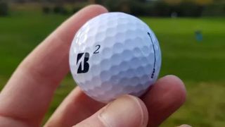 Bridgestone e6 Golf Ball held aloft on the golf course