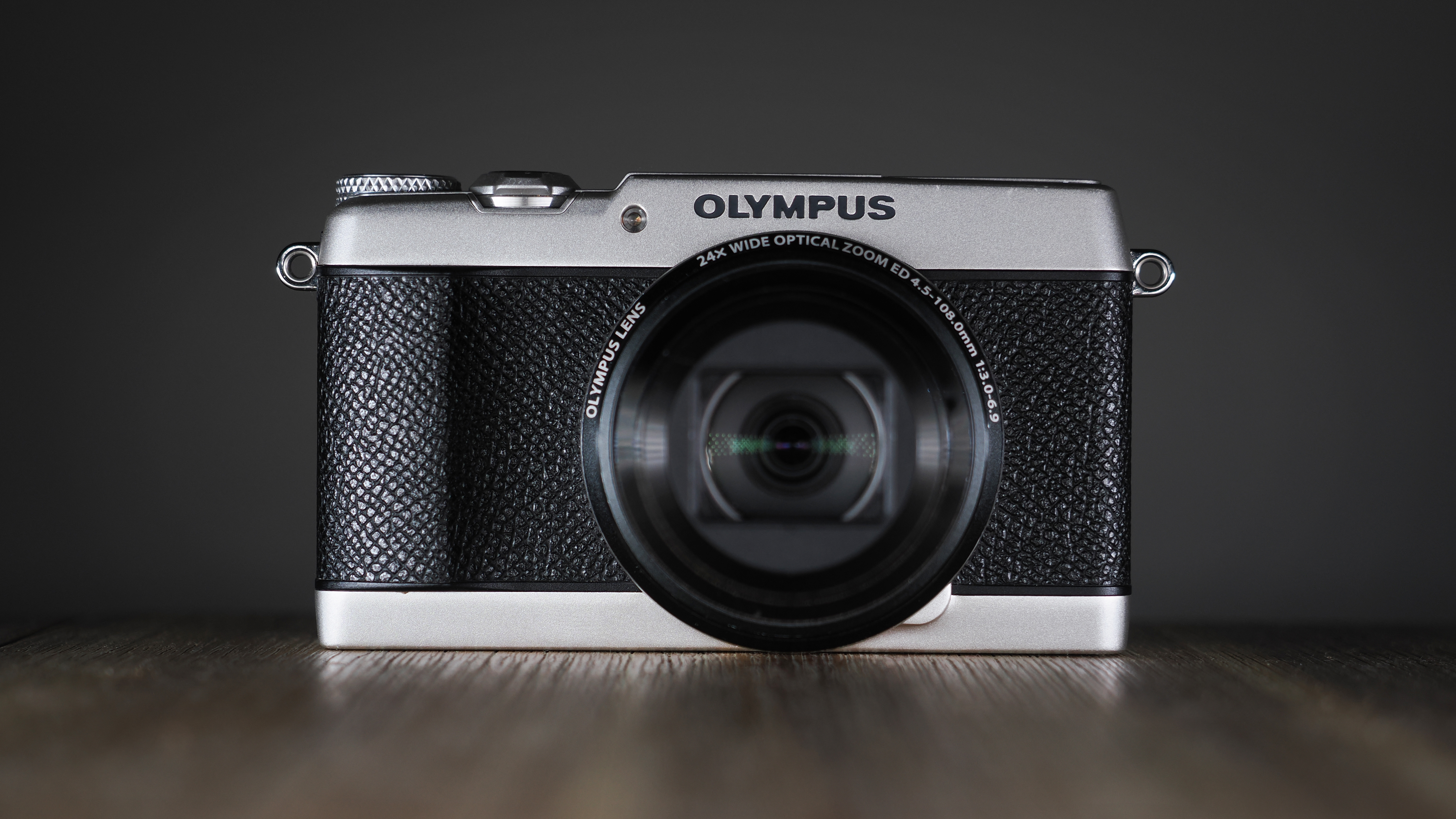 Olympus Stylus SH-3 on a wooden surface