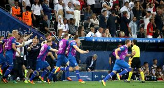 Roy Hodgson watches on as Iceland players and staff celebrate a 2-1 win over England at Euro 2016