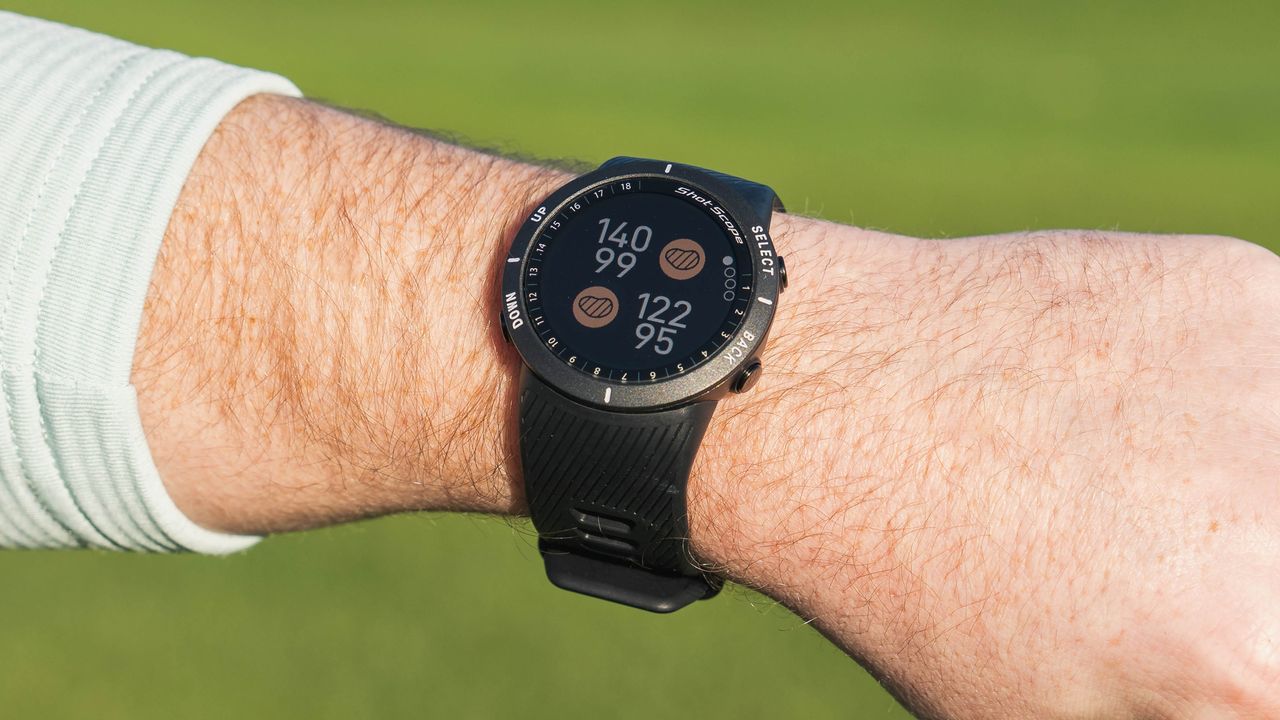 A shot scope v5 watch on a golfer&#039;s wrist