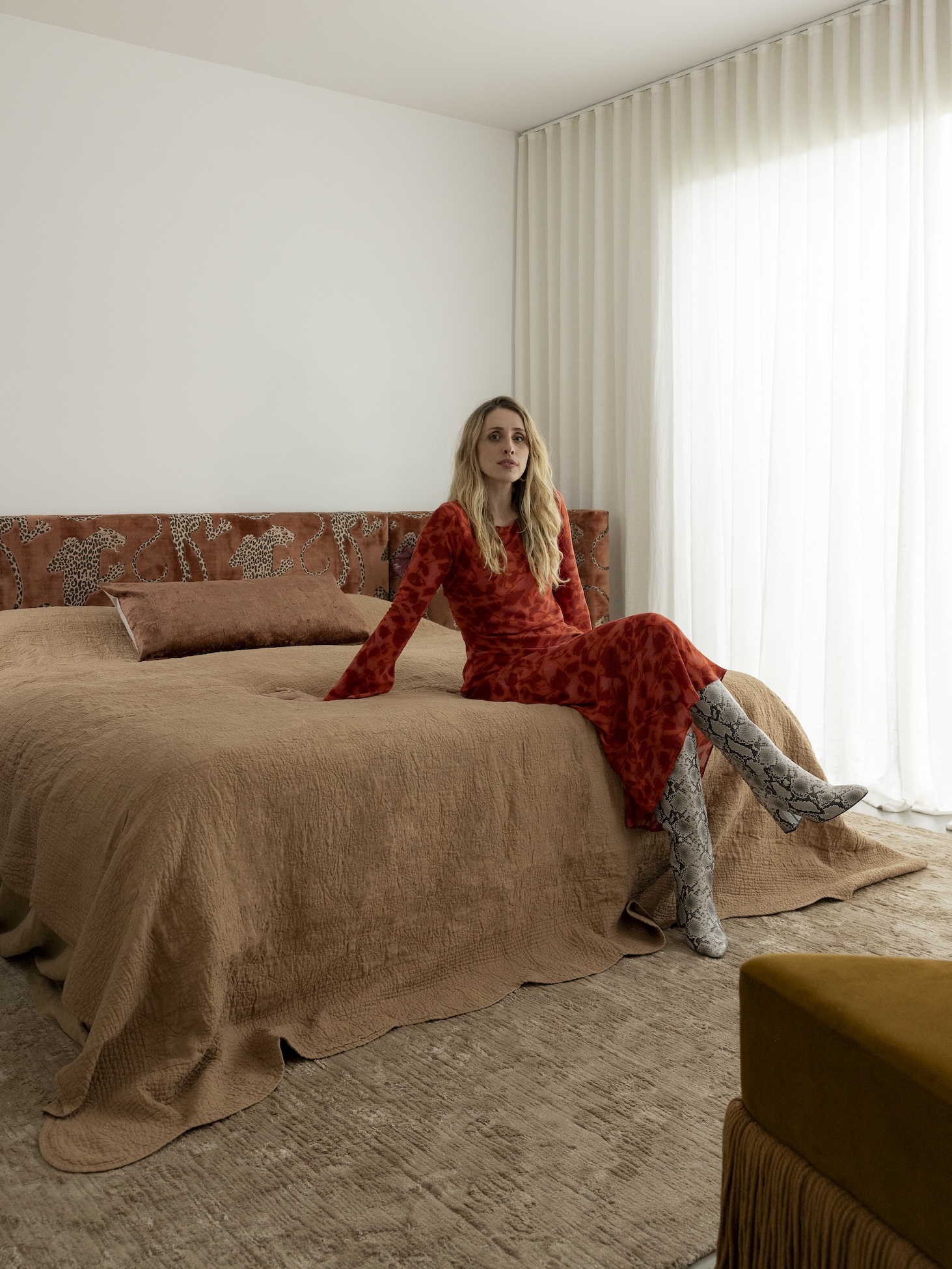 An image of interior designer Alyssa Owens sitting on a bed.