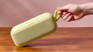 Man holding Bose SoundLink Plus by carry strap