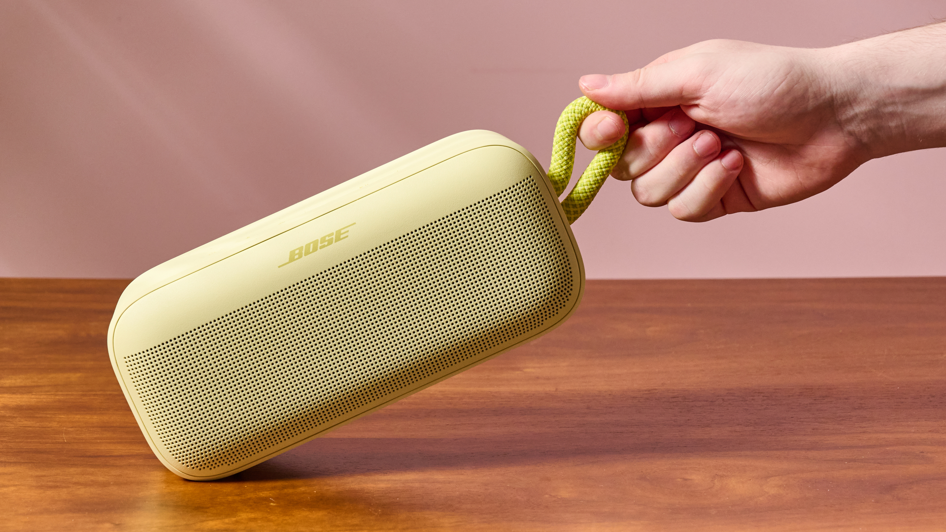 Man holding Bose SoundLink Plus by carry strap