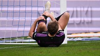 Harry Kane holds his knee after colliding with the post in Bayern Munich's win over Darmstadt in March 2024.