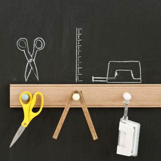 chalkboard with wooden hanger scissor measuring tape and punching machine