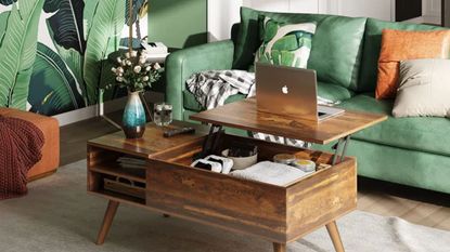 Grossi Coffee Table by George Oliver in a rustic oak finish inside a green living room with a green sofa, green plant wallpaper and a neutral rug