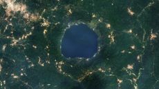 A 2015 satellite photo showing a series of golden tendrils surrounding a round blue lake
