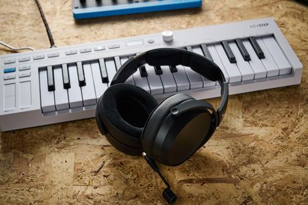 A pair of Sennheiser HD 480 Pro studio headphones leaning against a MIDI keyboard