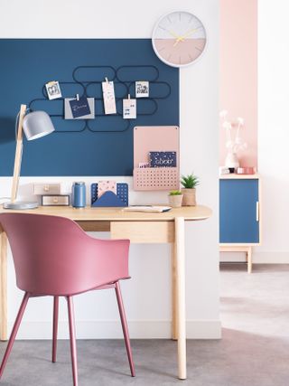 Maisons du monde feature chair in bright pink in a pink and white office with a wooden desk and a blue pinboard and side table