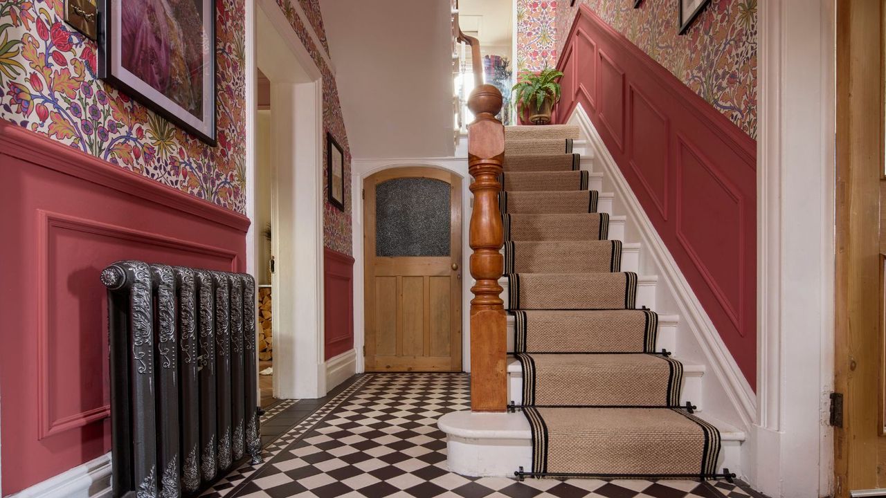 period hallway with checkerboard flooring and pink walls with floral wallpaper