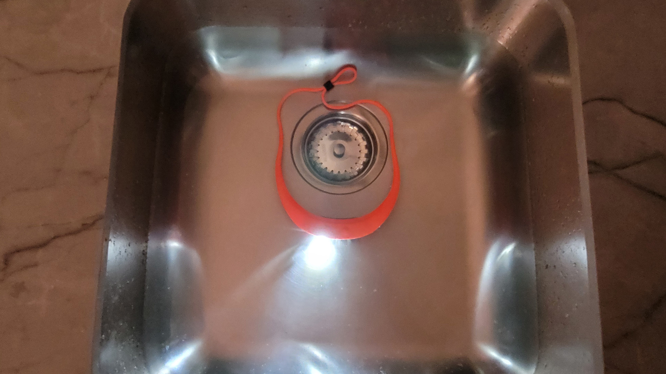 The Knog Bilby 400 submerged under water in a sink with the lamp on to demonstrate the IP67 rating