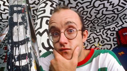 Keith Haring stands in front of his art in 1986