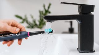 Washing an electric toothbrush under a tap