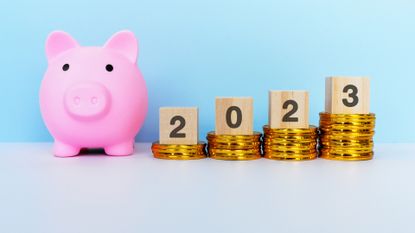 Image of a piggy bank, coins, and the calendar year 2023.