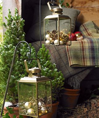 Outdoor lanterns filled with christmas baubles