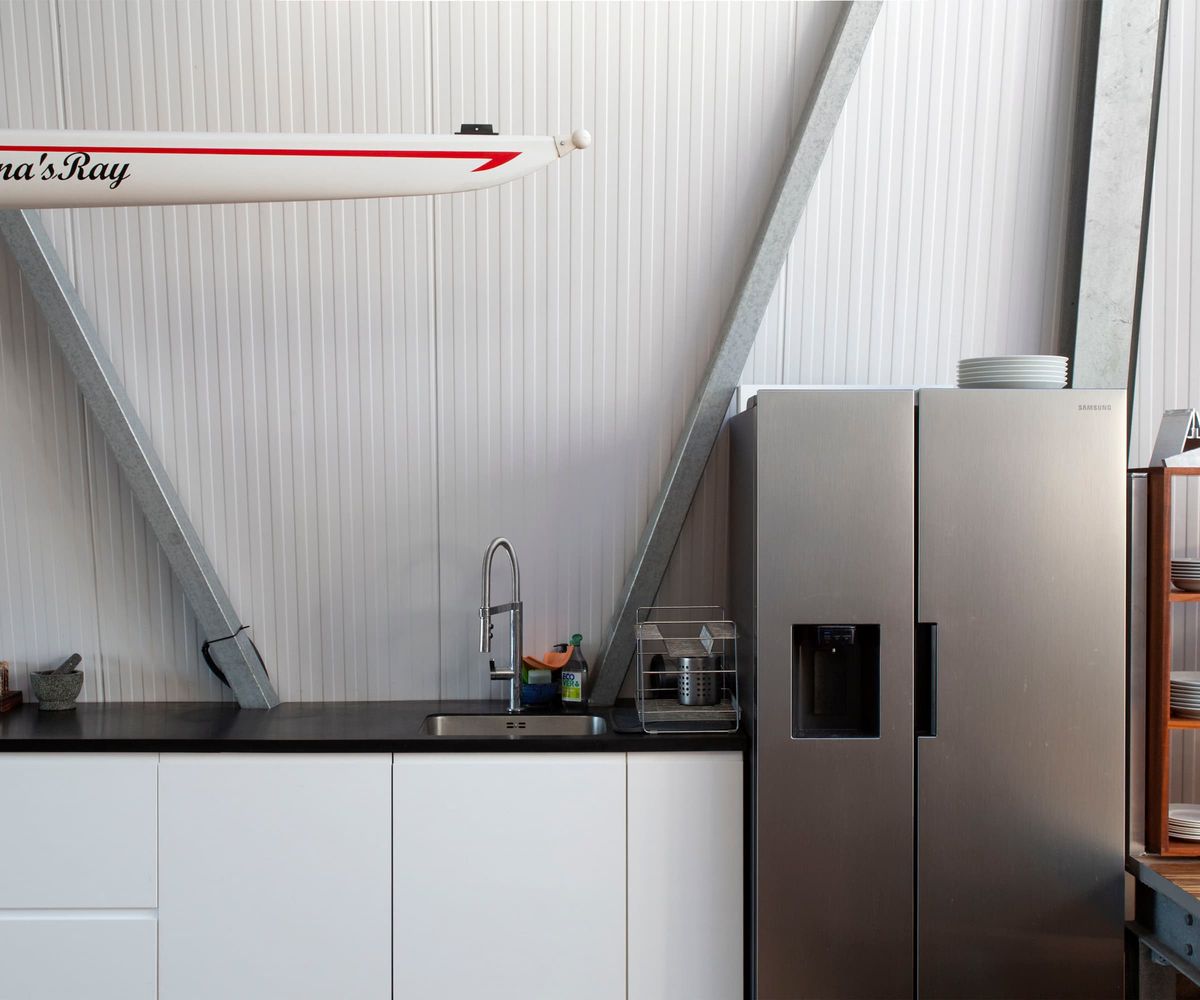 A kitchen with aluminium walls and a matt fridge