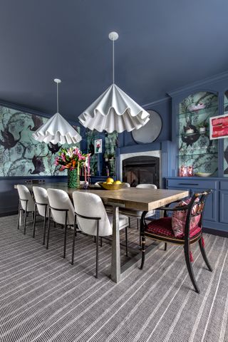 A dining room with blue walls and ceiling and turquoise wallpaper