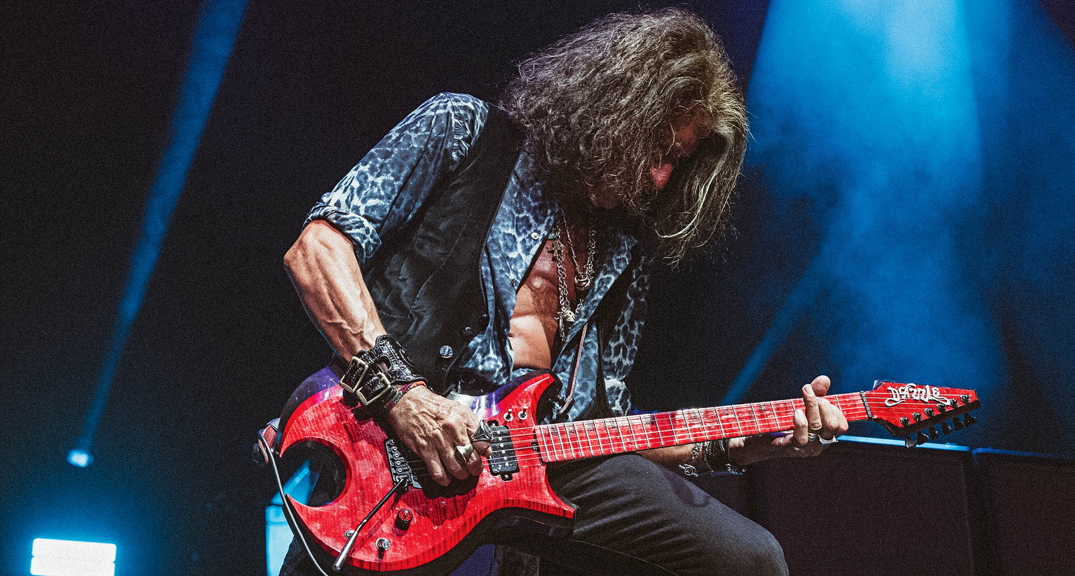Joe Perry plays his red custom Dazzle guitar onstage with Aerosmith.