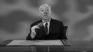 Alfred Hitchcock holding a gun in an Alfred Hitchcock Presents opening segment