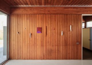 Wood panelled wall with hanging artworks