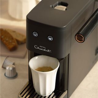 Hotel Chocolat Podster coffee machine pouring coffee into white mug