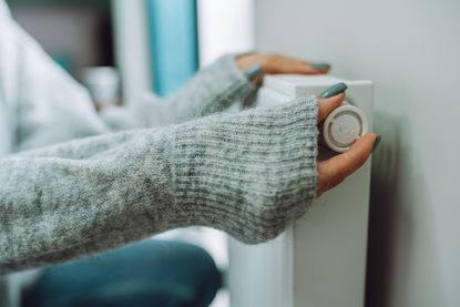 Woman turning on the radiator