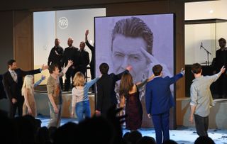 From left, cast members Tom Parsons, Sophia Anne Caruso, Michael C Hall, Amy Lennox, Michael Esper, Julie Yammanee and Jamie Muscato pay tribute to playwright David Bowie at the curtain call during the press night performance of "Lazarus" at the King's Cross Theatre on November 8, 2016, in London.