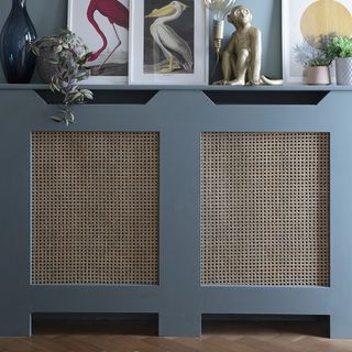Radiator cover in a hallway painted in blue with rattan lining.