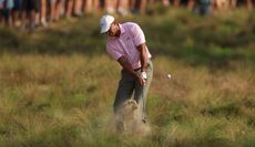 Tiger Woods hits a shot from the sand