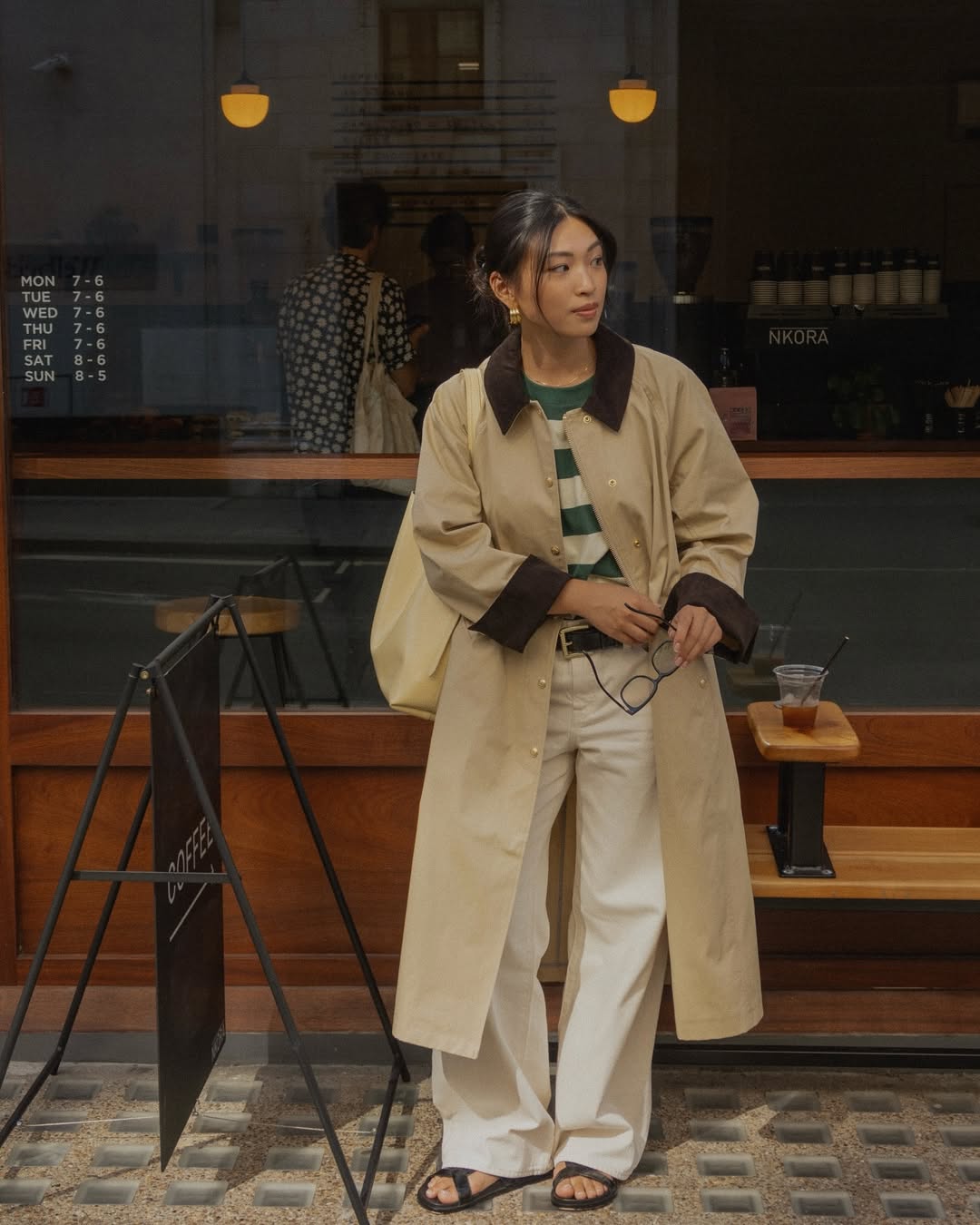 @michellelin.lin wears a trench coat, striped t-shirt, ecru jeans and sandals