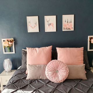 bedroom with photoframe on blue wall and bed with pillows