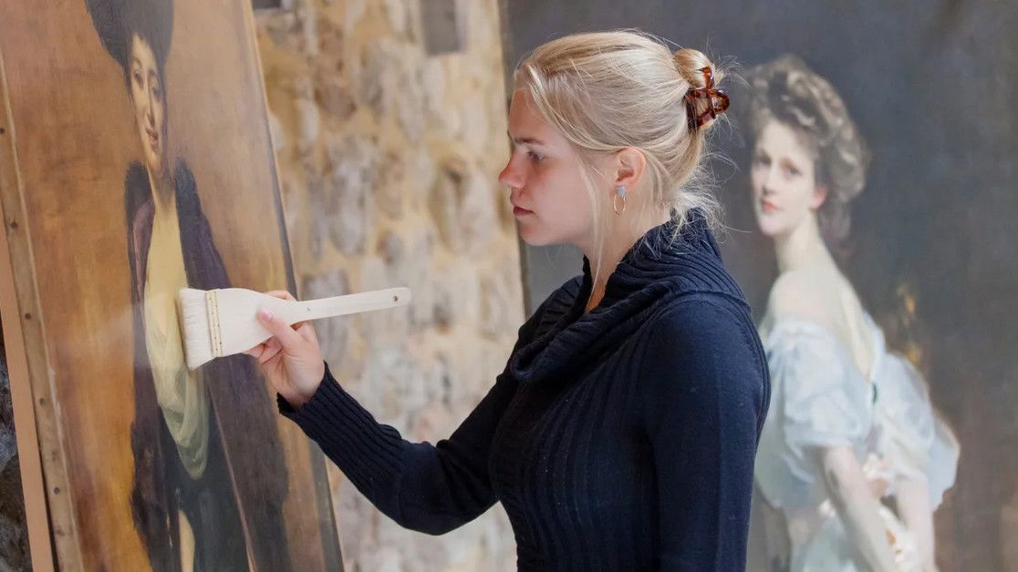 Conservator working on portraits in the Royal Oak Foundation Conservation Studio, Knole, in Hidden Treasures of the National Trust