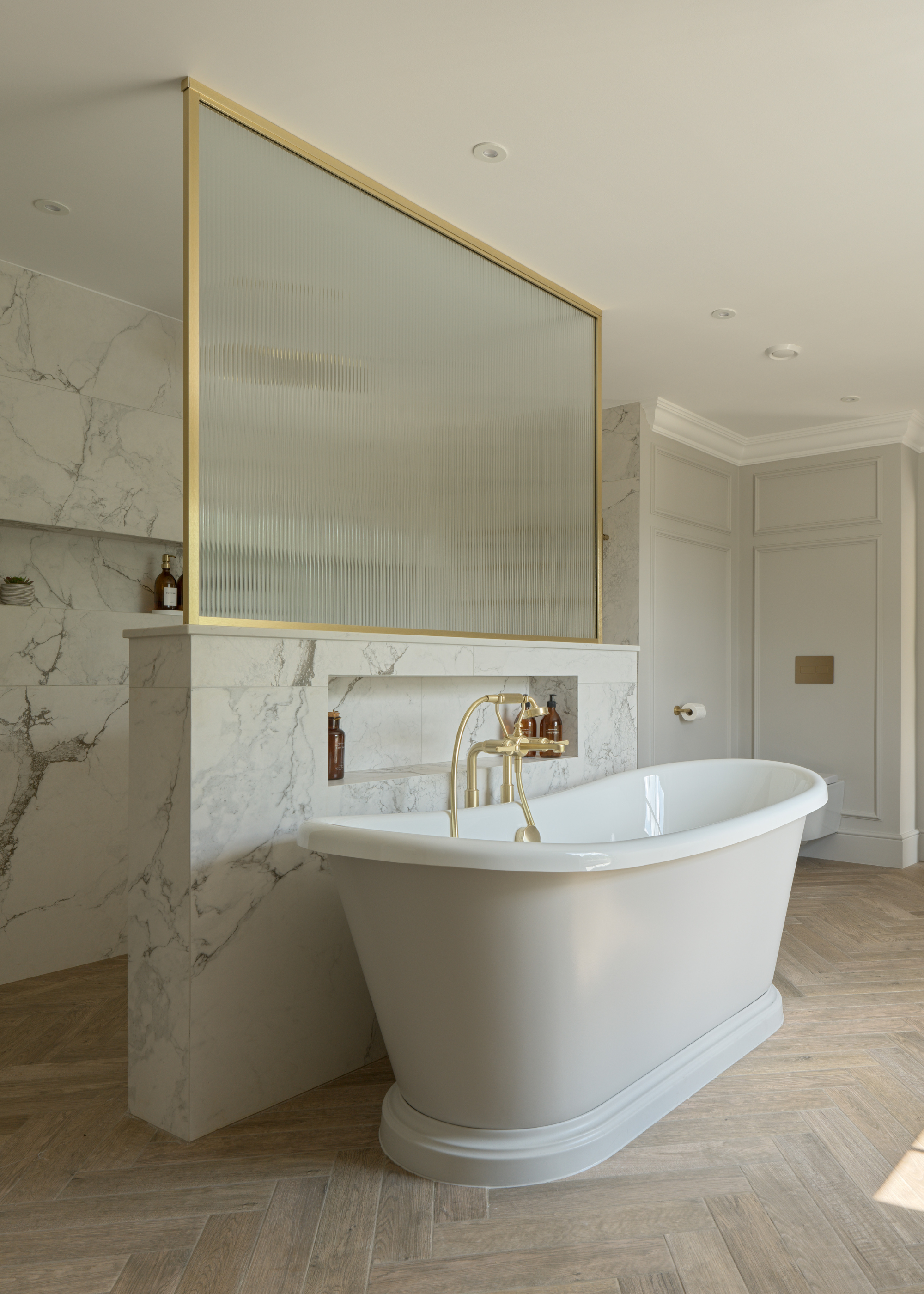 white freestanding roll top bath in front of an open shower