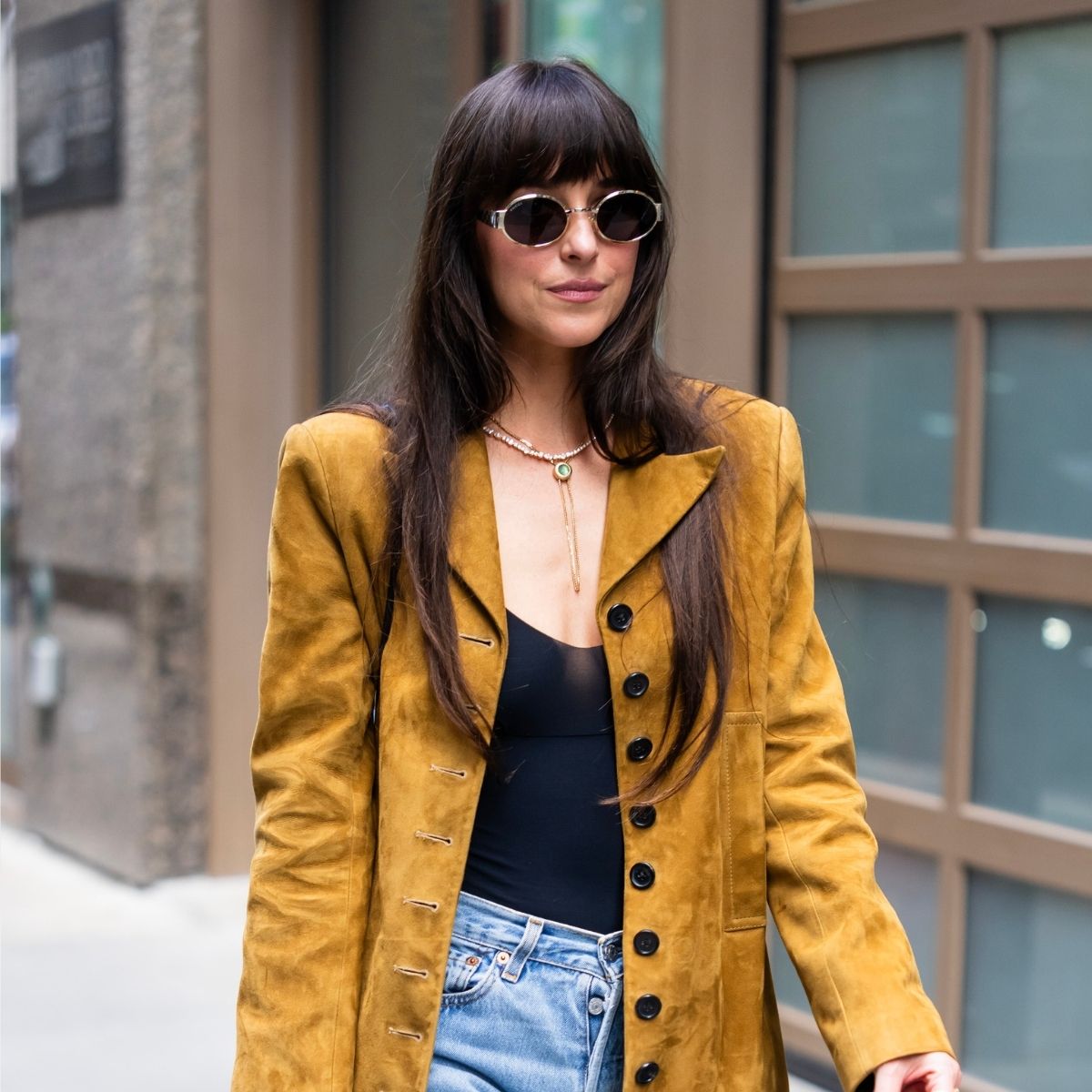 Dakota Johnson is seen in Midtown on May 30, 2025 in New York City, wearing jeans, a suede blazer and sunglasses