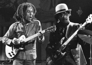 Bob Marley (left) and Aston “Family Man” Barrett perform onstage with the Wailers at the Odeon in Birmingham, England on July 18, 1975